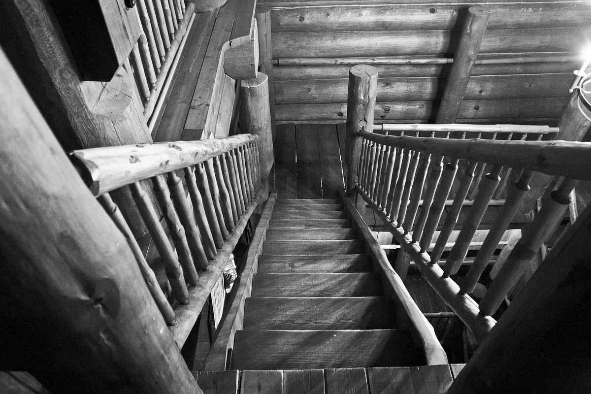 Escalier en bois avec rampes en rondins, intérieur de cabane rustique