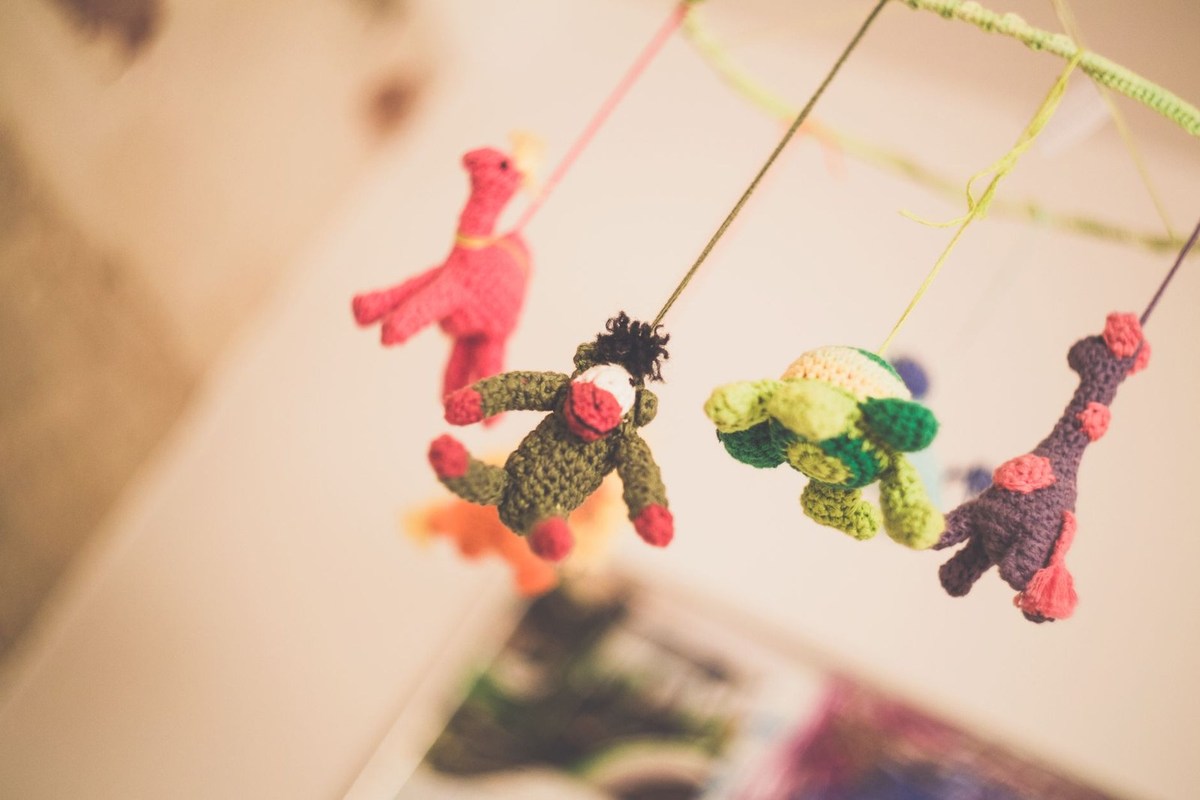 Jouets tricotés colorés suspendus à des fils, avec des animaux comme personnages Jouets tricotés colorés suspendus à des fils, avec des animaux comme personnages