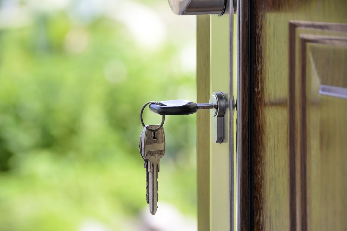 Clé insérée dans la serrure d'une porte en bois Clé insérée dans la serrure d'une porte en bois