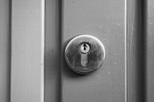 Une porte grise avec une serrure circulaire en métal