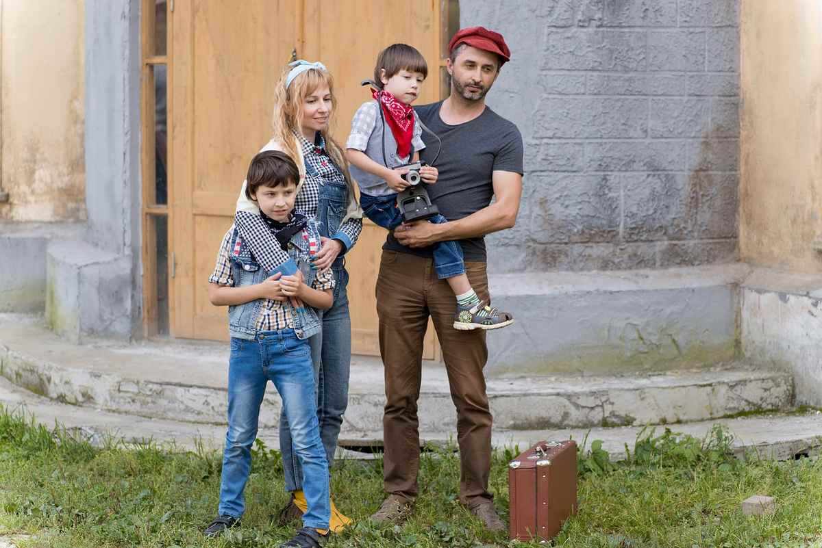 Une famille de cinq personnes devant une maison Une famille de cinq personnes devant une maison
