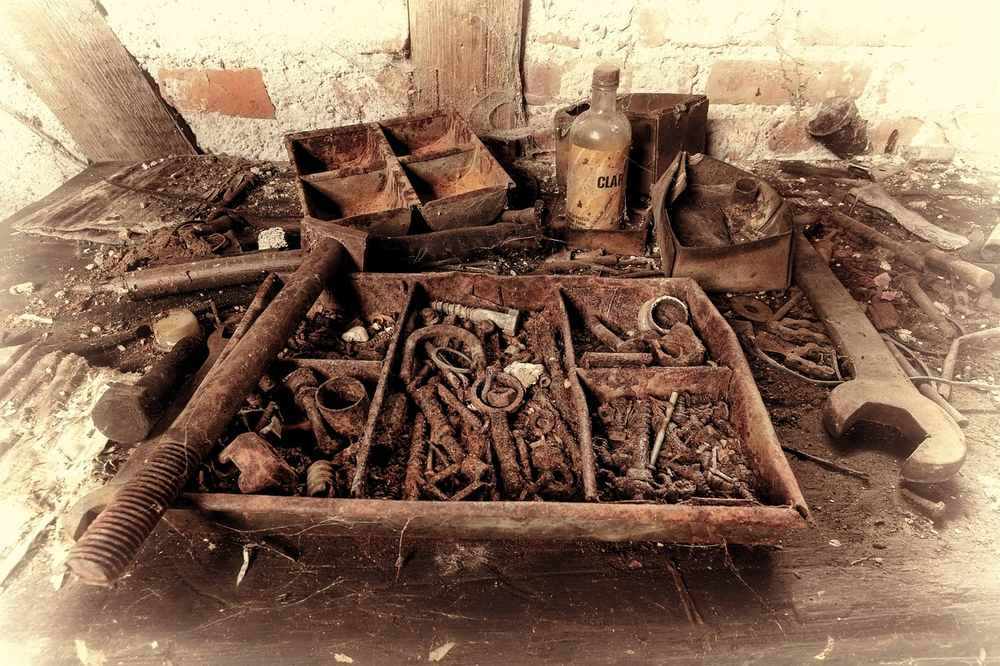 Boîte à outils antique remplie d'outils rouillés sur une table en bois